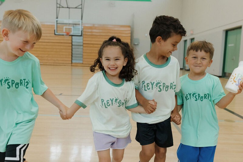 kids holding hands smiling at pley sports camp