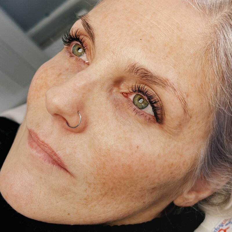 Close-up of green eyes with volume lash extensions styled for natural-looking fullness.