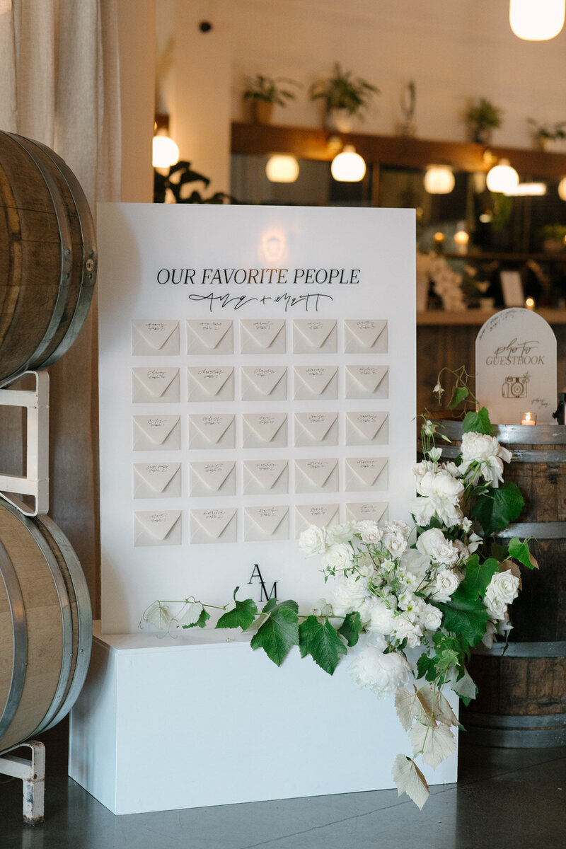 A custom wedding seating chart with customized calligraphy and envelopes on a board by Life in Letters.