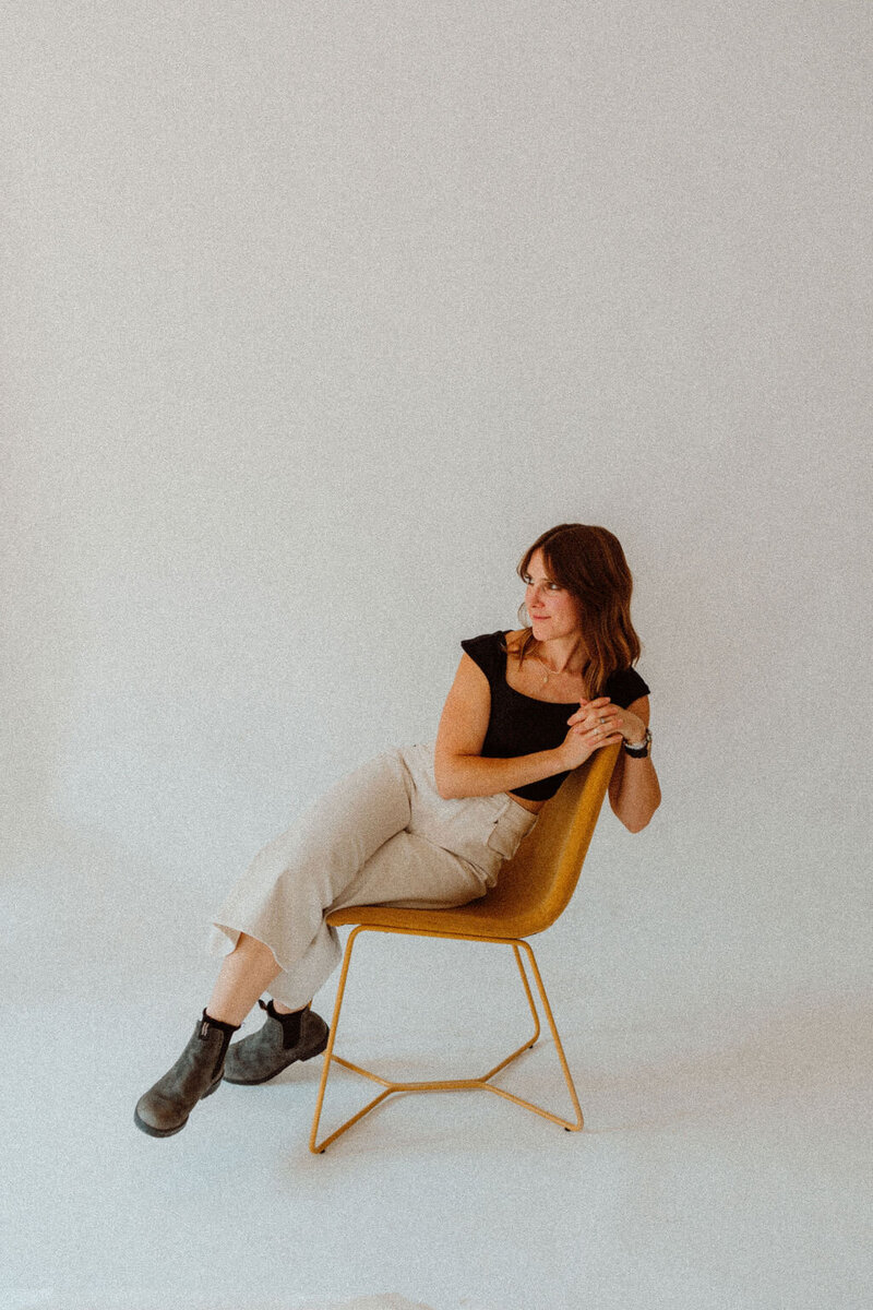 Boise event planner Alex sits in a chair and looks off to the side. 
