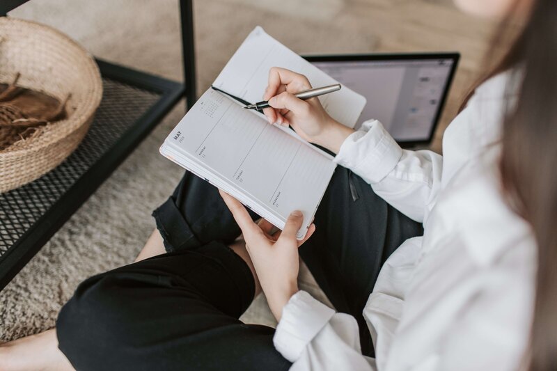 Two female business owners working on laptop and making notes