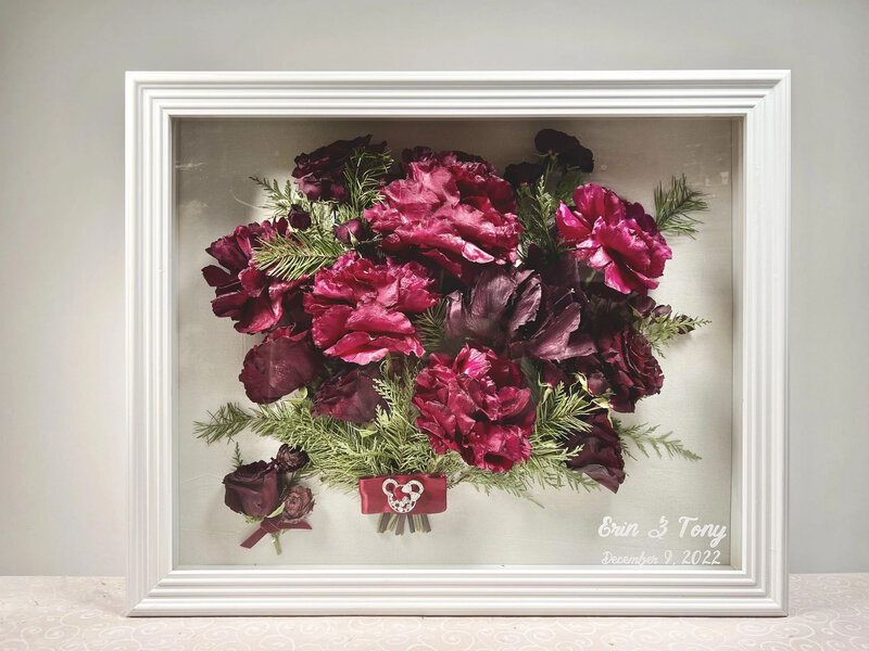 Vibrant preserved wedding bouquet of deep red roses in a classic white frame