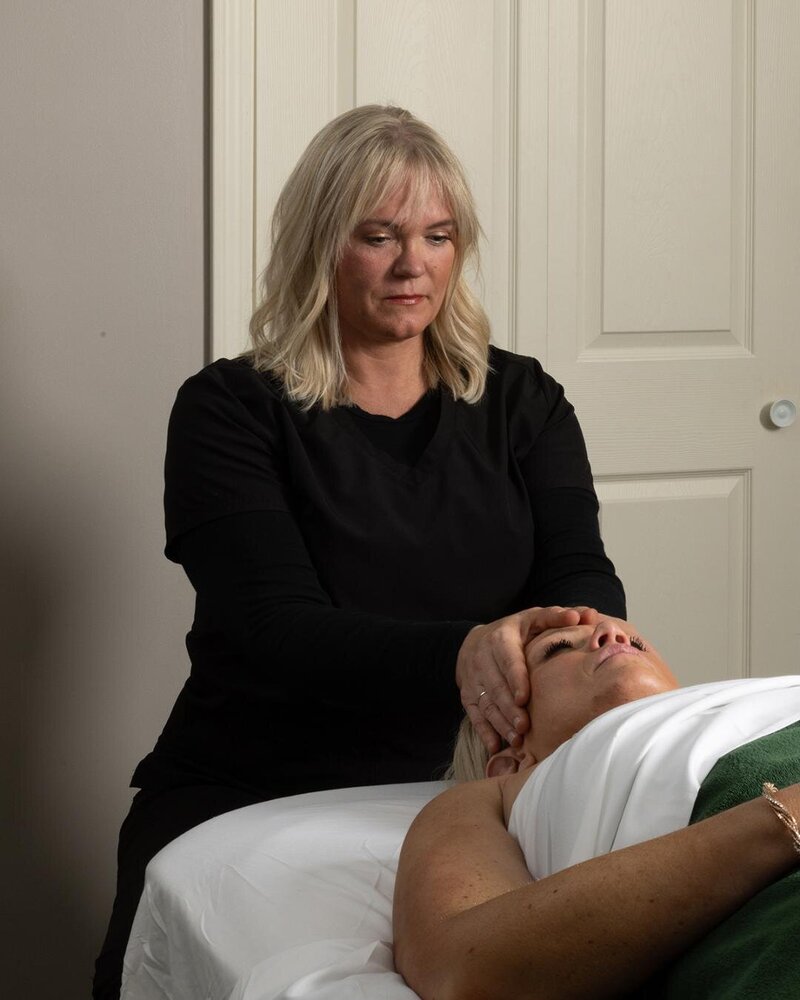 Massage therapist Booke Pederson giving client a facial massage