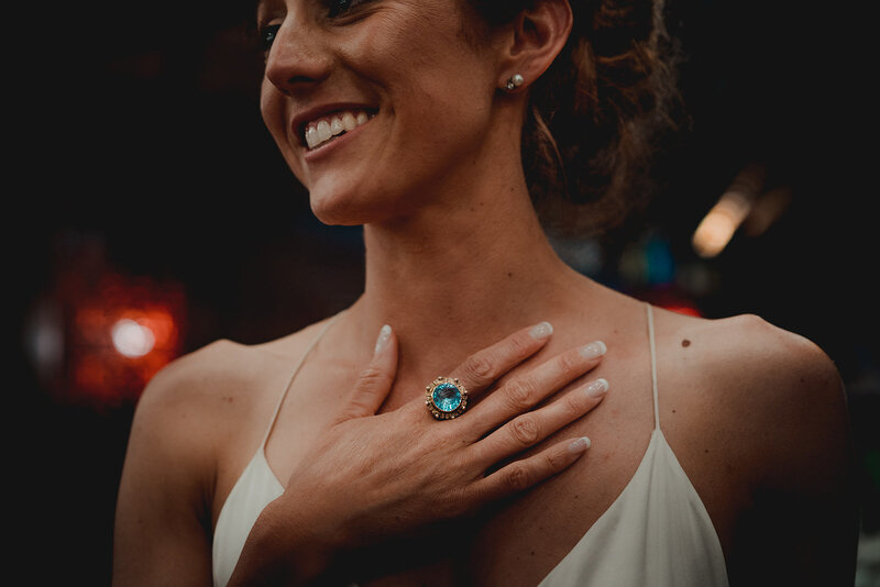 portrait of a bride with a focus on her wedding ring with large blue stone
