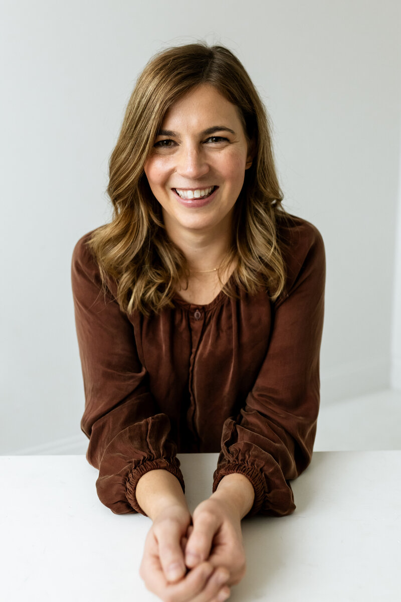 Chelsey, a therapist at Nova North Therapy in Medina, MN, smiling in a brown blouse against a neutral background.