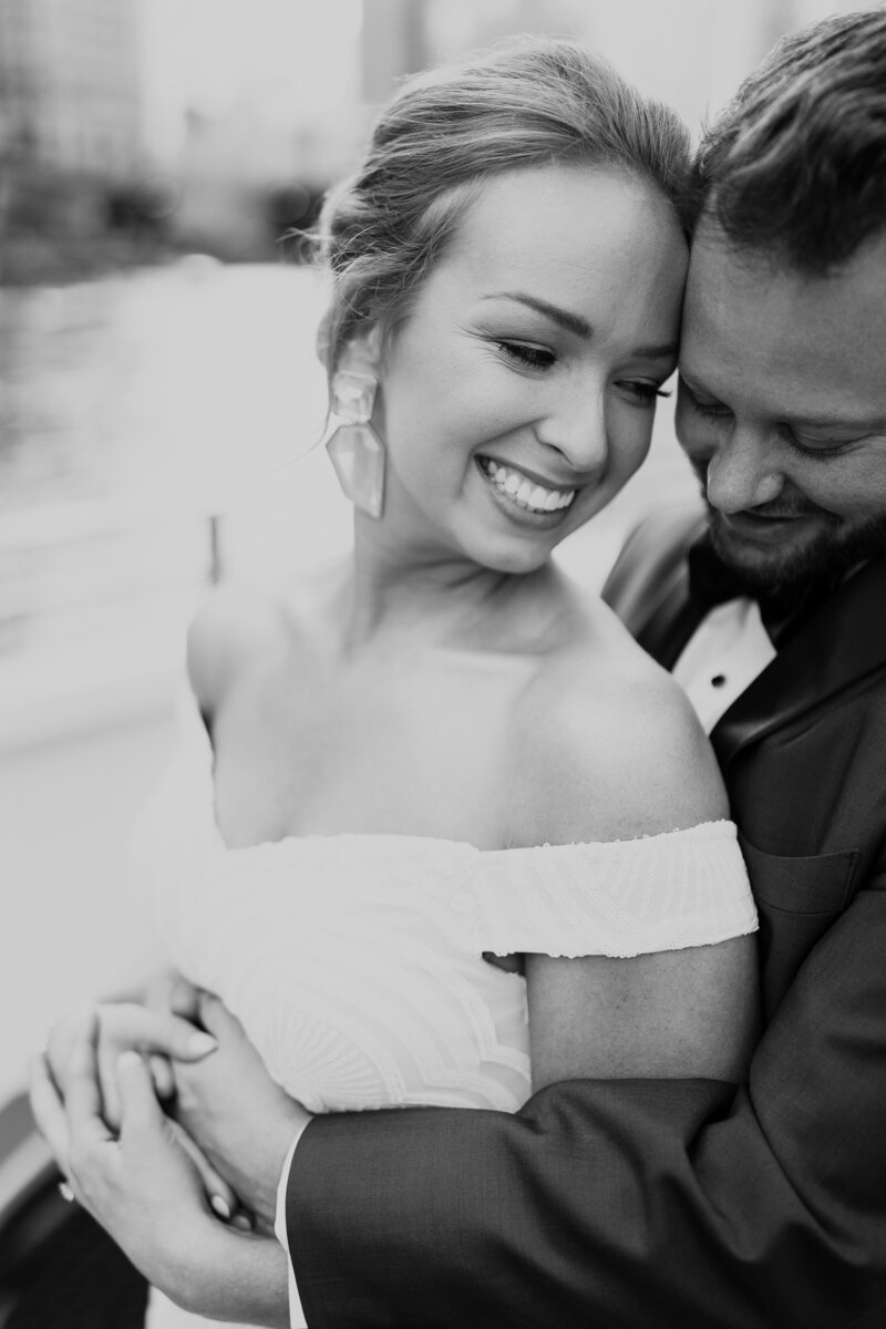 Black and white wedding session photo of bride smiling  and looking away from camera