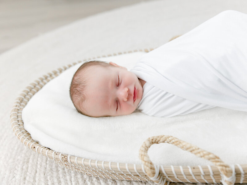 Close up image of a newborn baby in a moses basket
