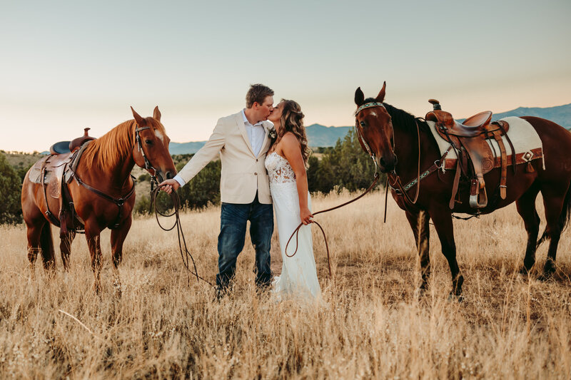 Couple stops for a kiss during their horseback elopement in Telluride, Colorado.