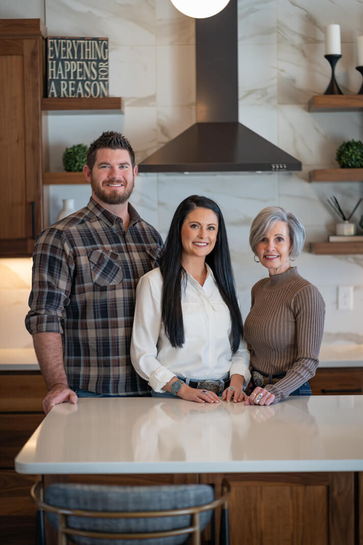 man and two women standing in a kitchen smiling