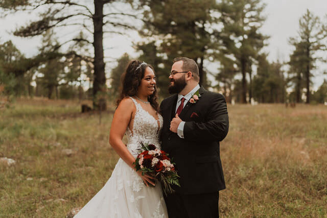 A wedding couple standing together in a field.