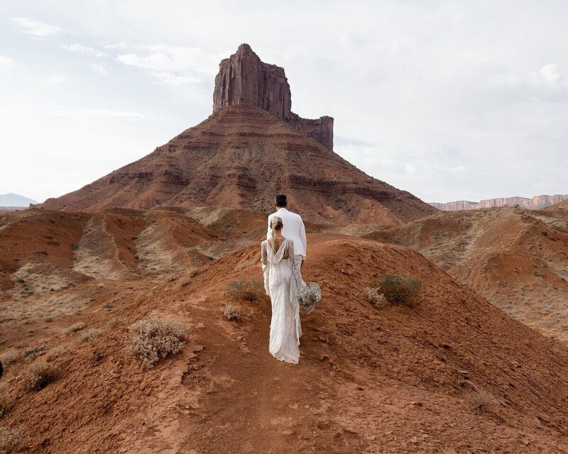 couple walking to their elopement ceremony in Moab
