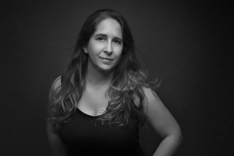 woman standing in front of a dark background in a studio