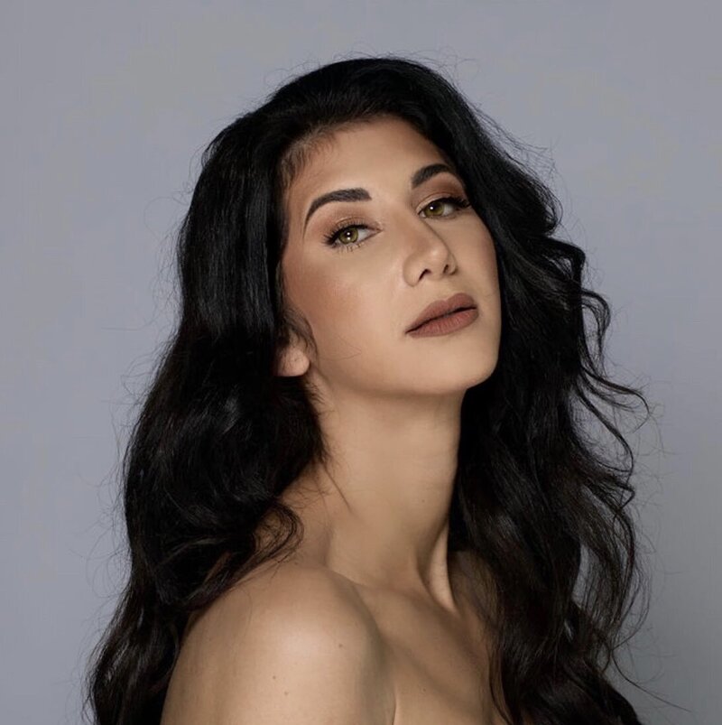 Client with soft glam makeup and voluminous dark waves, featuring neutral tones and a flawless complexion by Blushed Miami.