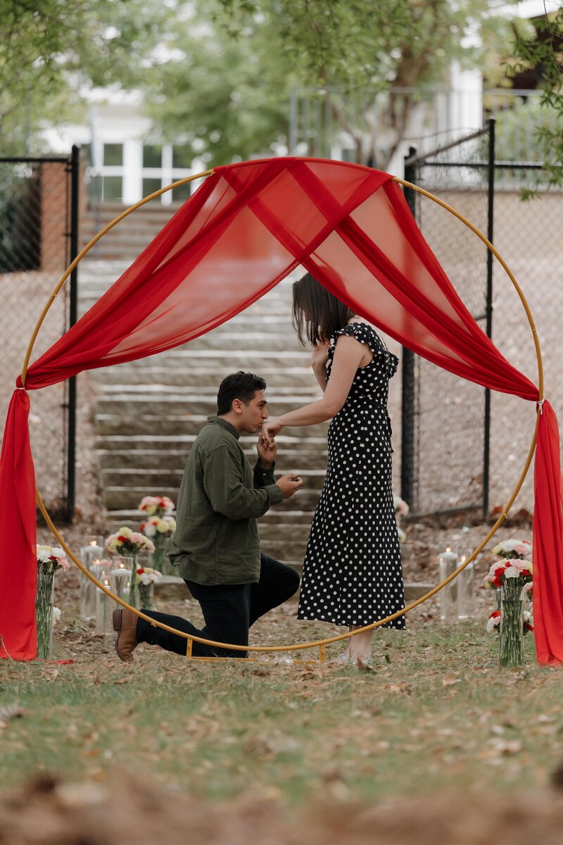 Man proposing in Marietta in front of draped arch.