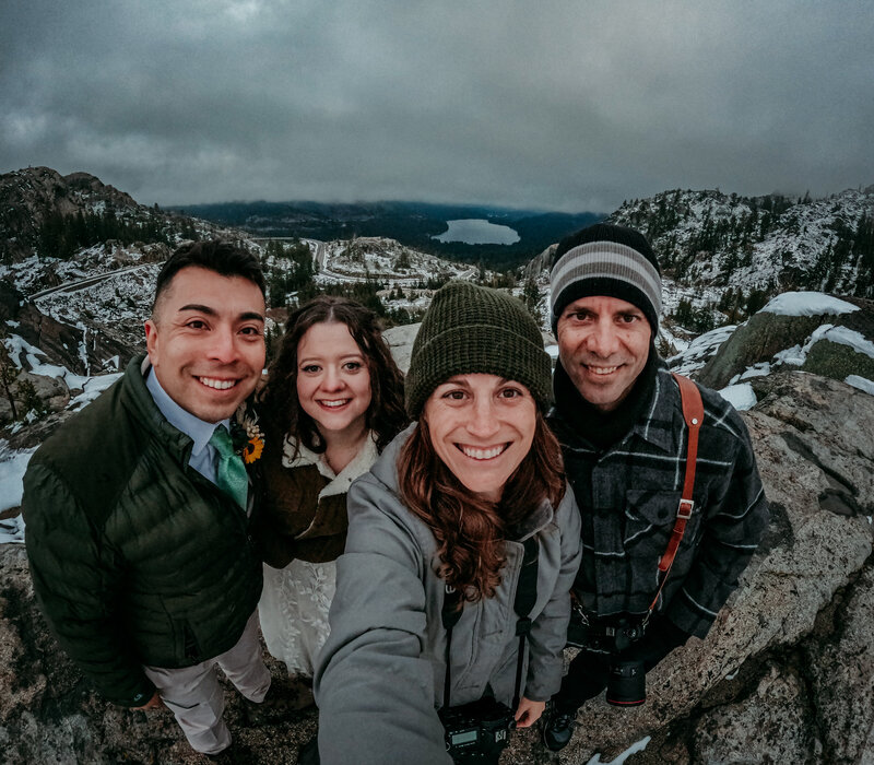 Kristin Smith and her husband Rick, Lake Tahoe elopement photographers, smiling with a couple after their snowy winter elopement overlooking Donner Lake.