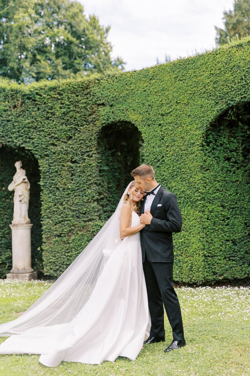 Een bruid en bruidegom genieten van een intiem moment tijdens hun bruiloftsdiner, omringd door natuurlijke groene decoraties.