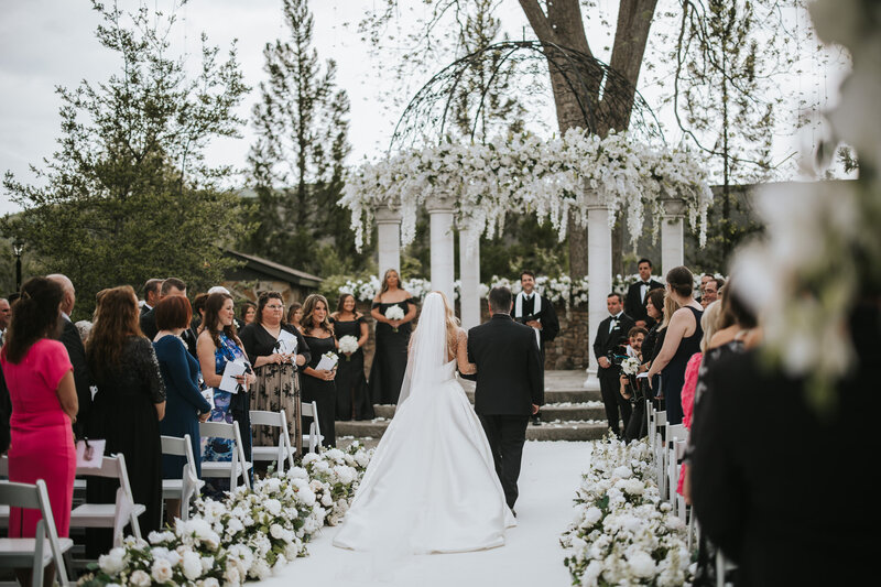 Bride gracefully walking down the aisle, a beautiful moment captured during the ceremony.