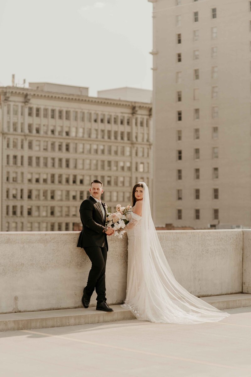 Couple Standing on Rooftop with City Skyline in Background - Darby & Garrett | Timbers on Pacific Wedding Spokane Washington