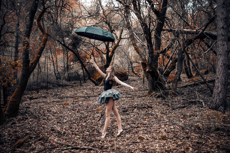 Dancer with umbrella in forest