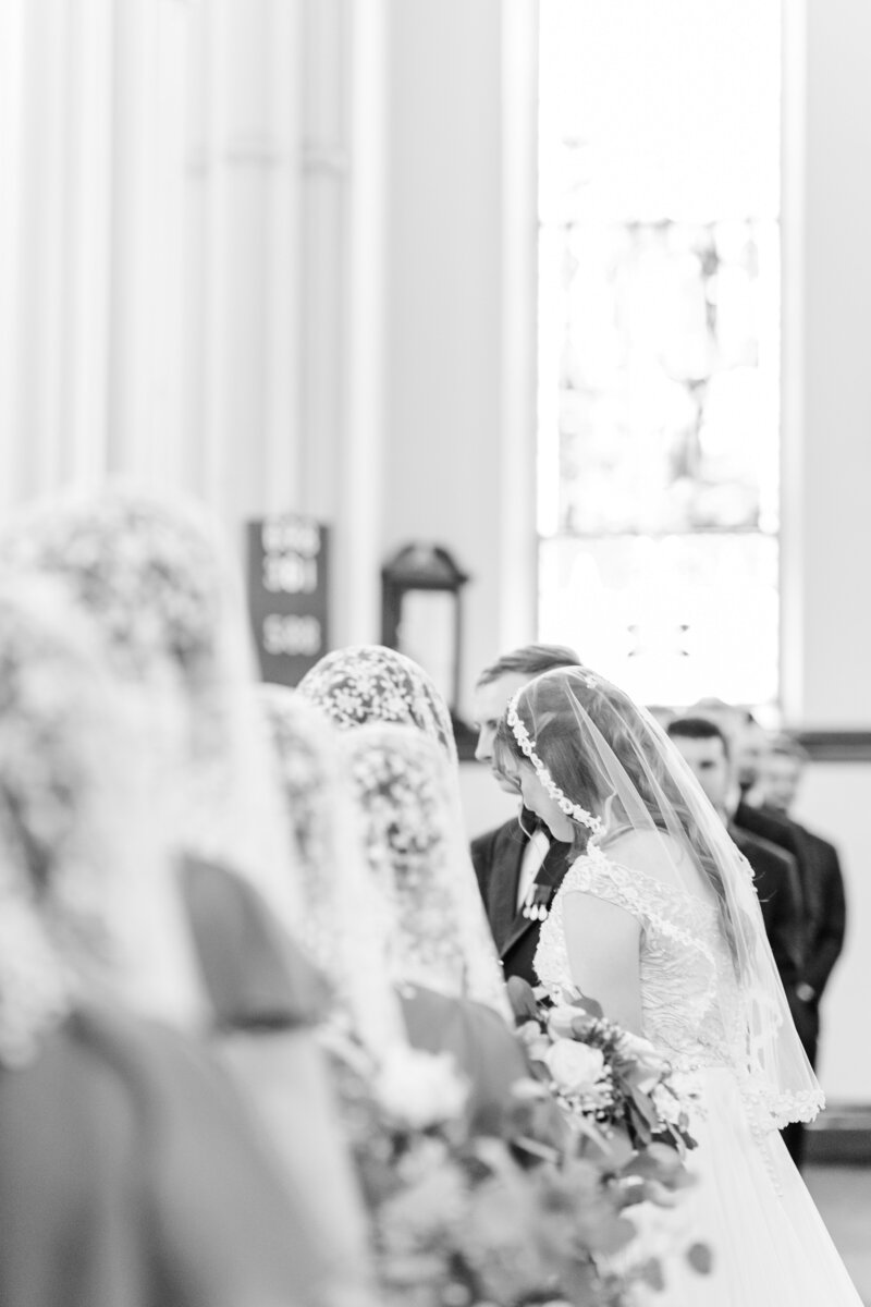 a Catholic bride and groom participating in their wedding ceremony