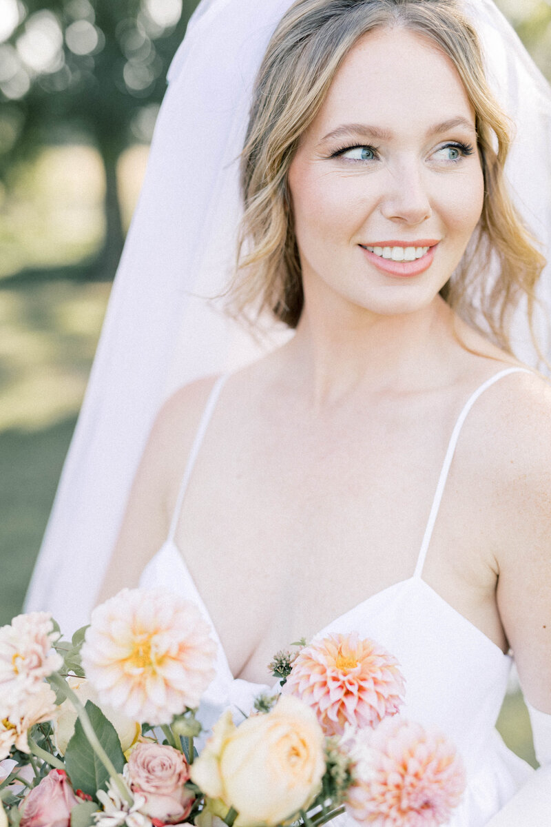 knoxville bride smiling while holding thistle and lace boquet