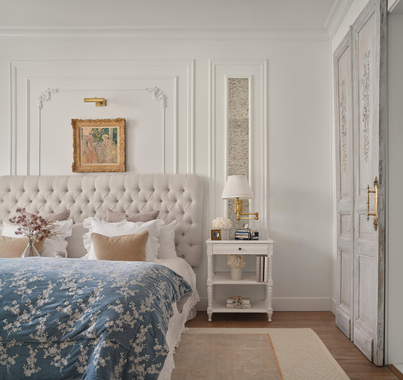 luxury bedroom with white dresser  white nightstand  and bed with blue blanket