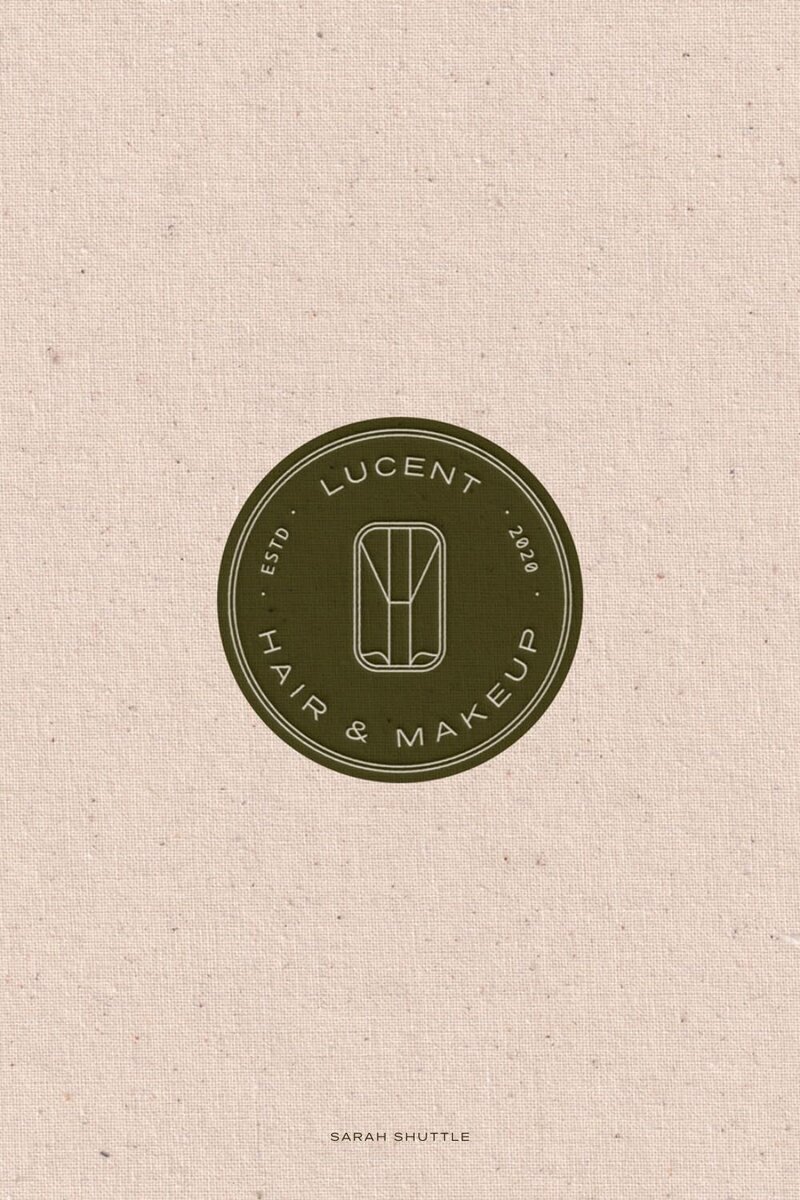 Lucent submark printed on a soft cotton texture, highlighting the warm, tactile elements of the beauty brand.