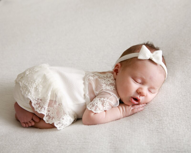 Newborn girl in ivory lace dress