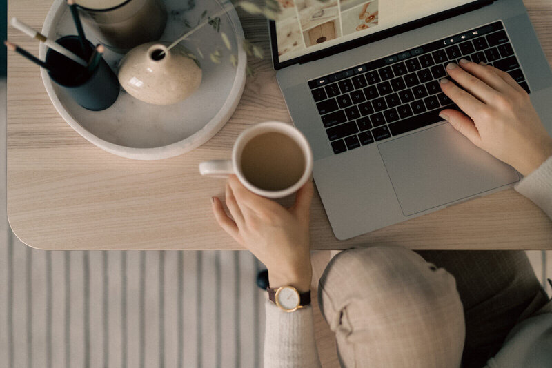 A woman working on her laptop at home, demonstrating concentration and productivity in a comfortable setting.