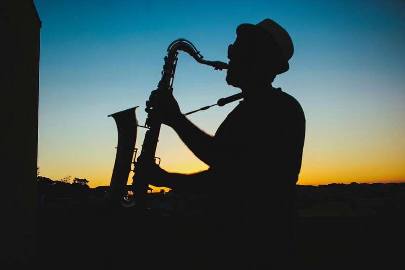 a street musician playing a sax at sunset in kansas city