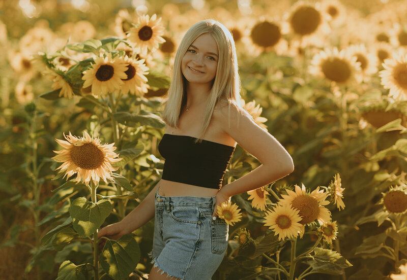 girl in sunflower field for senior portraits