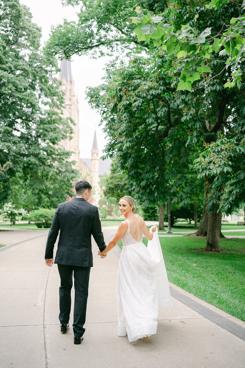 Bride and Groom walking on God Quad toward the Basilica of the Sacred Heart on the campus of the University of Notre Dame
