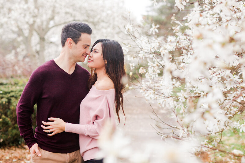 Man an woman embracing by cherry blossom tree