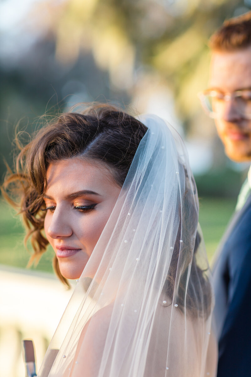 A Bride and Groom at the altar having their portrait taken, surrounded by a huge flower arrangement.