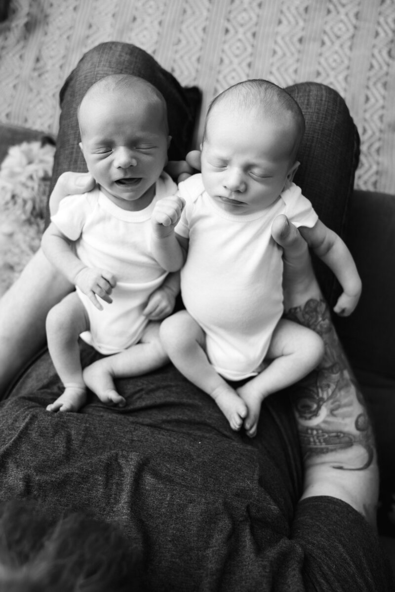 newborn twin boys in father's arms during a Seattle area in-home lifestyle newborn photography session.