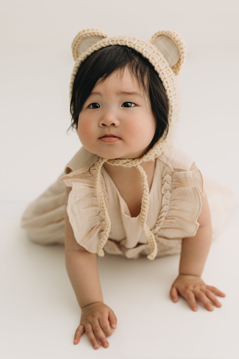 Asian baby wearing bear hat in studio
