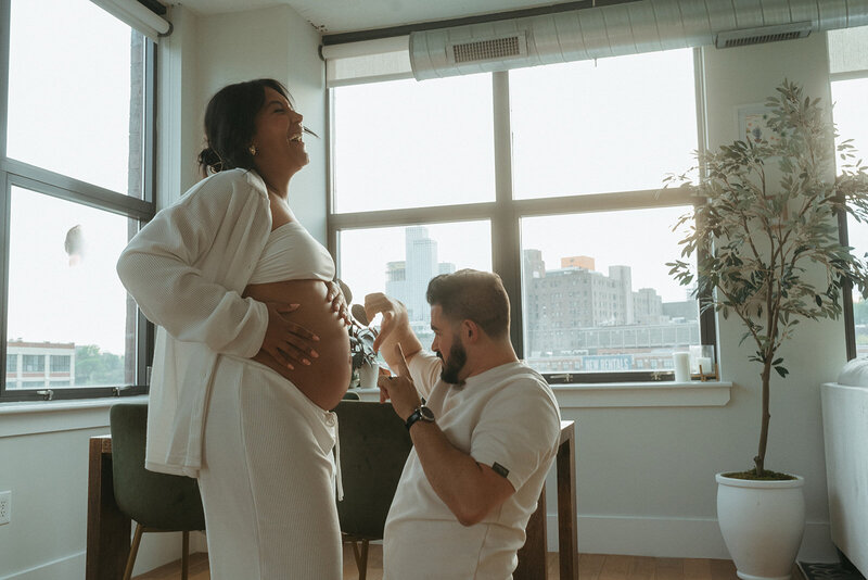 couple laughing and posing during maternity photoshoot captured by NYC maternity photographer Elsie Goodman 
