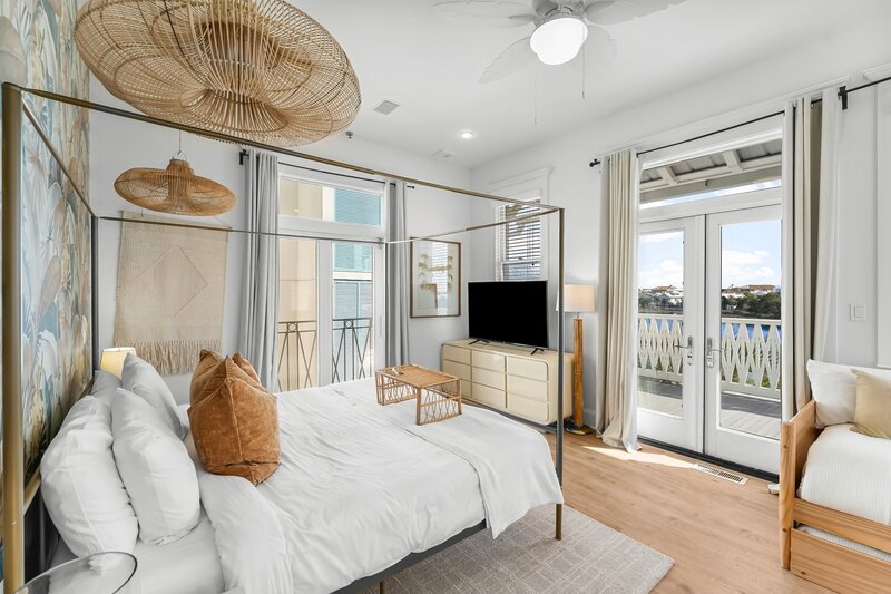 Light-filled king bedroom with private lakeview balcony at The Florida House, a Carillon Beach vacation home near Panama City Beach and 30A.