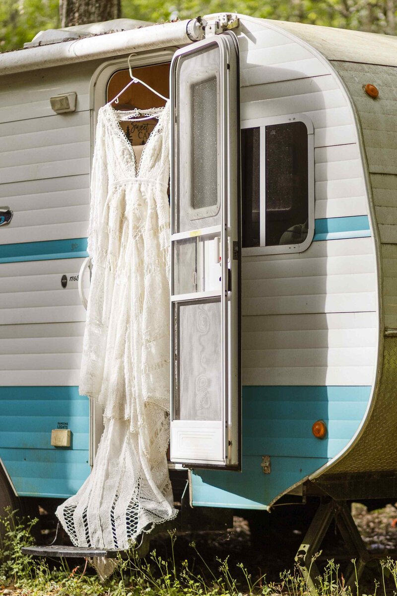 Wedding dress hangs from a vintage campervan door