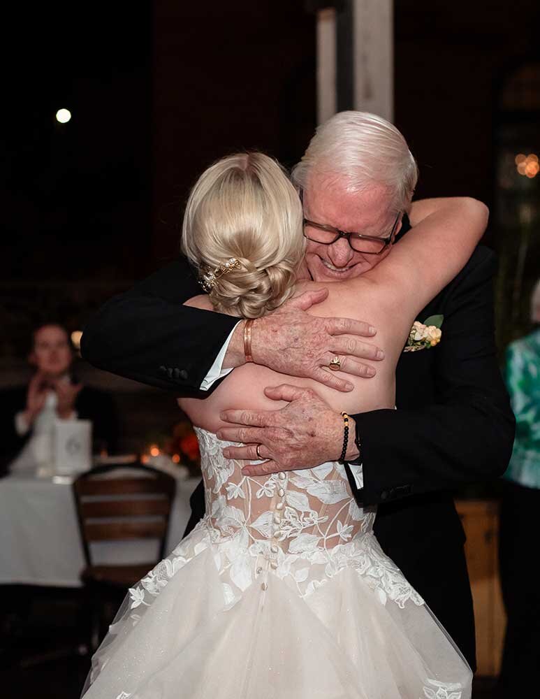 Father of the bride tearful hug at reception