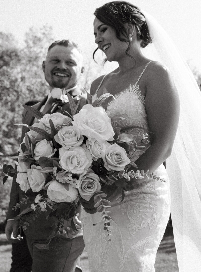 Candid wedding moment at Agar’s Corner, Saskatoon. The bride and groom celebrate their intimate wedding day with laughter, love, and a timeless bouquet.