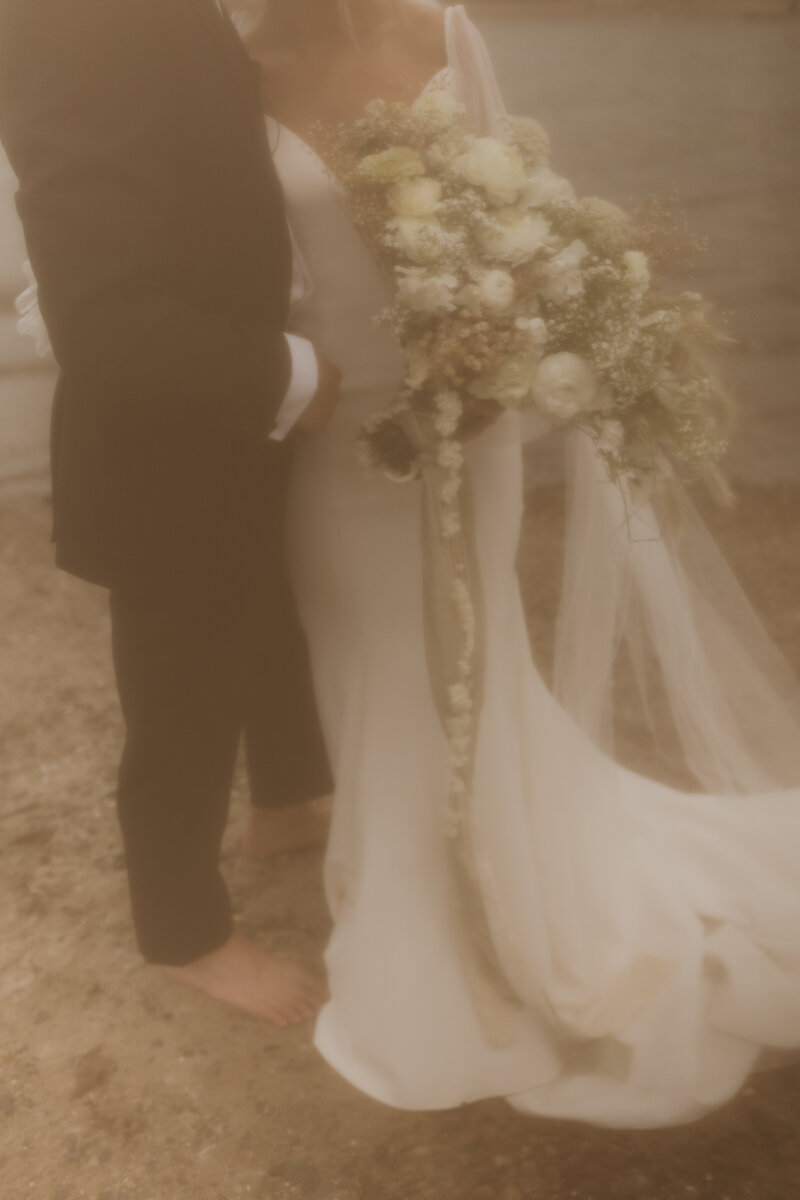 bride and groom walking in front of adobe house