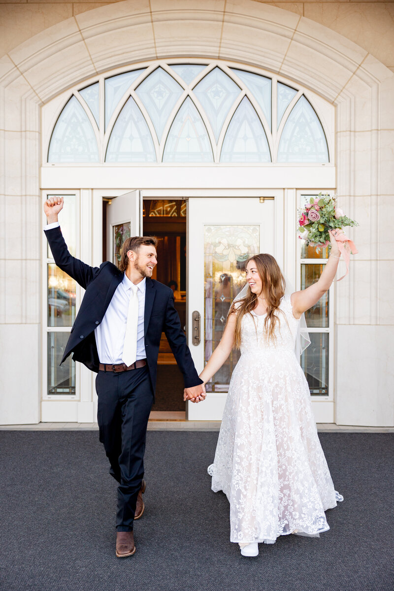 The bride and groom cheer and smile at each other as they exit the Taylorsville Utah LDS Temple