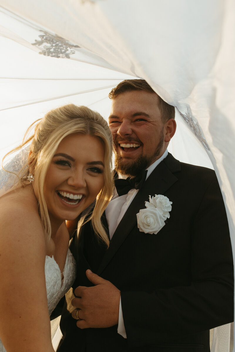 bride and groom laughing as they dance into their wedding dinner