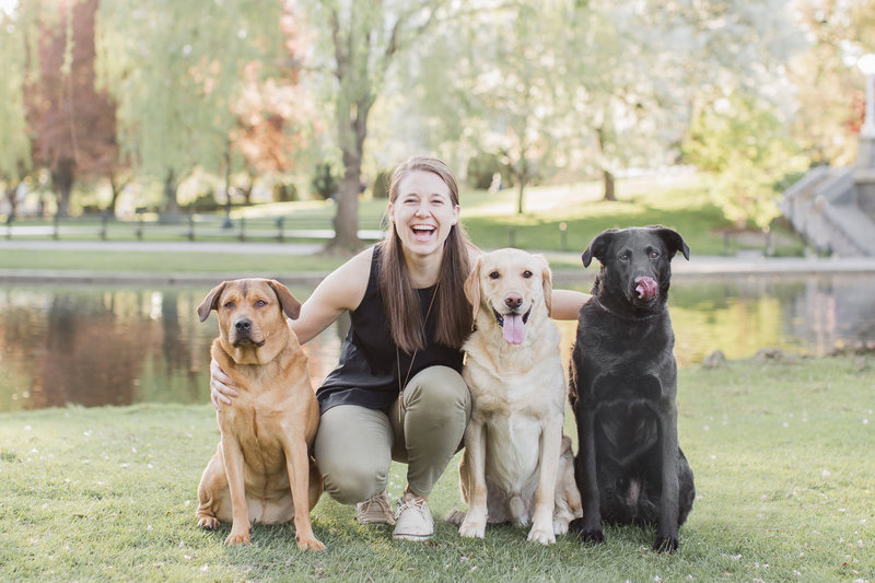 Woman sitting with dogs in park