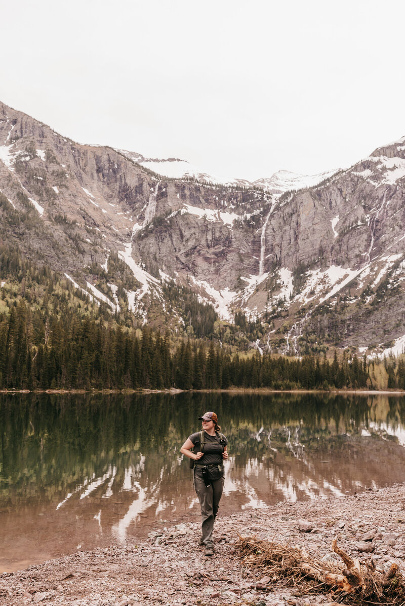 Montana Elopement Photographer poses in front of alpine lake in Glacier National Park.