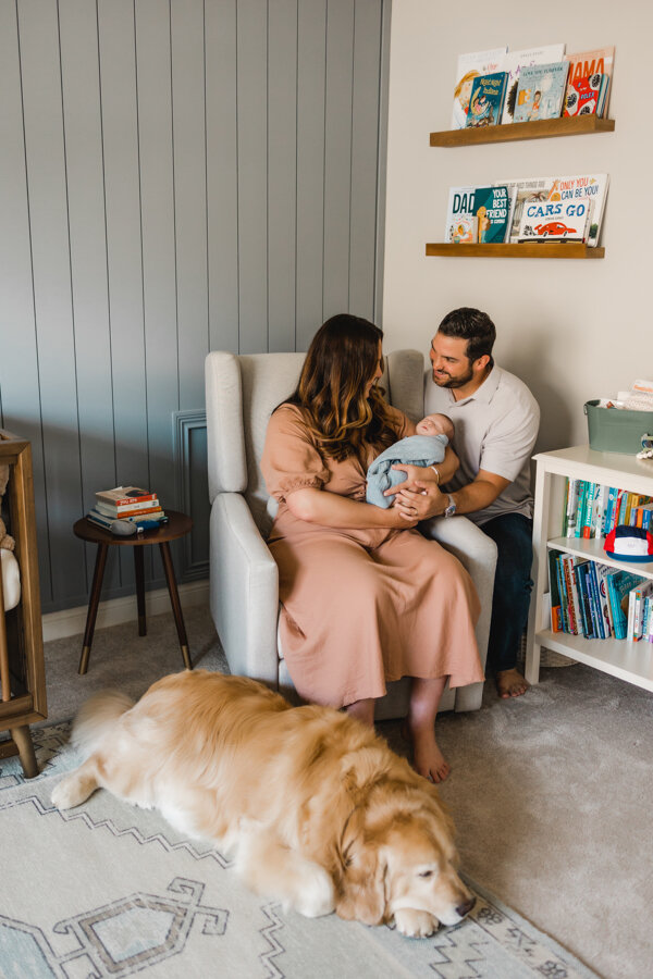 parents sitting with their newborn baby and dog