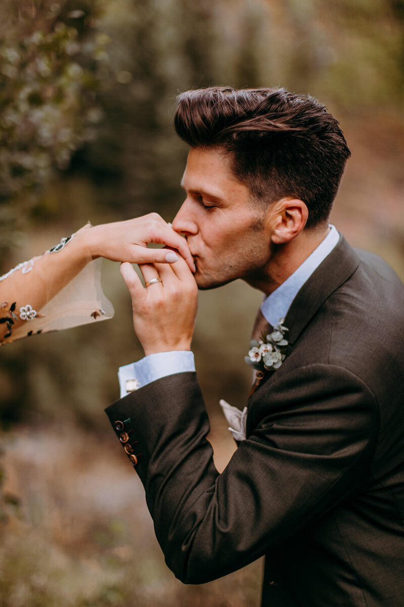 maroon bells elopement groom kissing brides hand