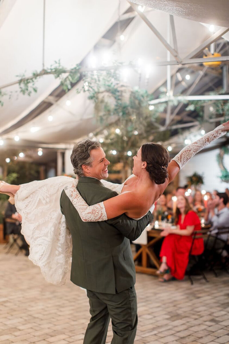 Groom carrying her bride in a traditional wedding dance