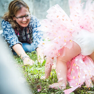 Happy smiling photographer with toddler in tutu